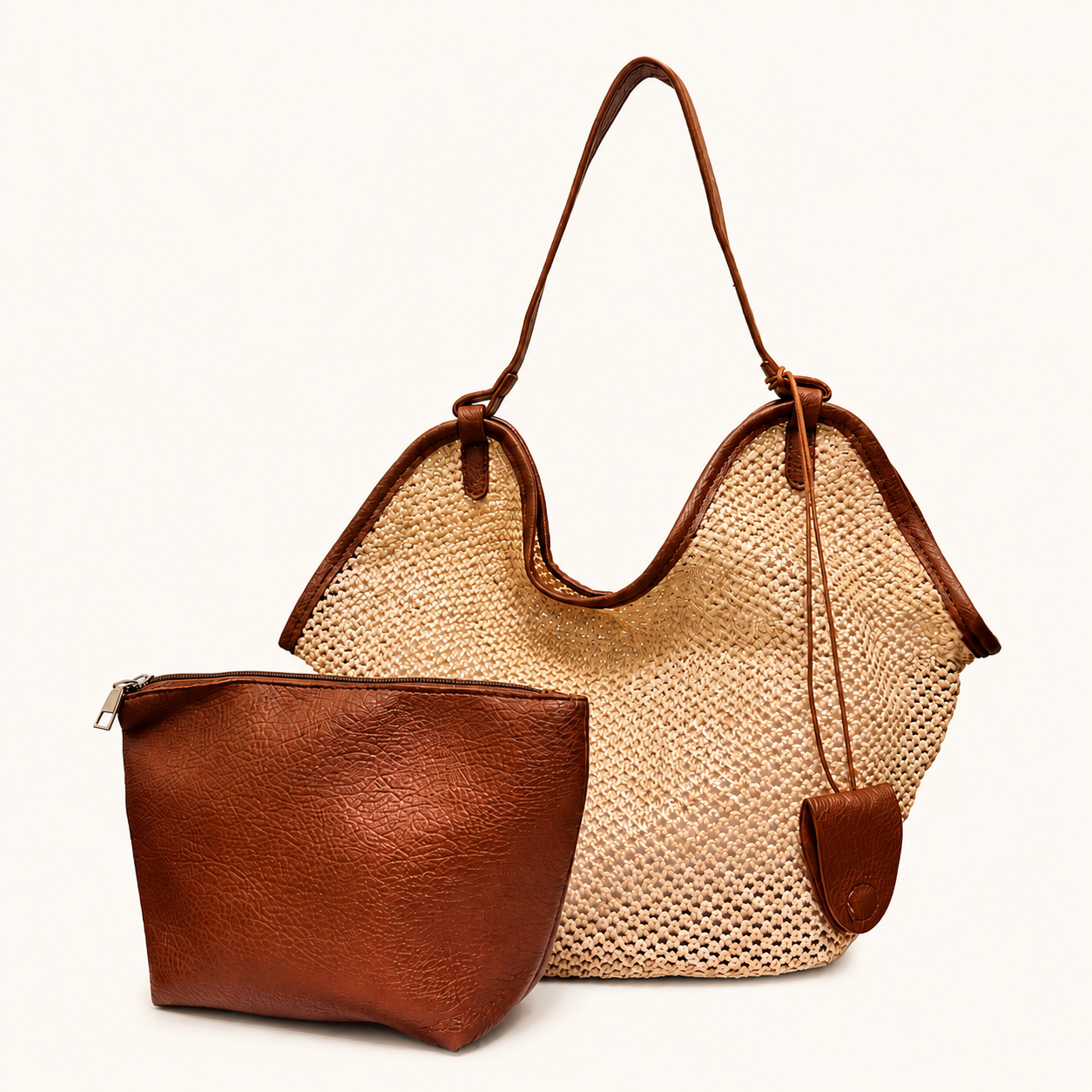 A natural woven straw beach bag styled with a brown vegan leather pouch and matching charm, made for summer travel, beach days, and casual everyday use.