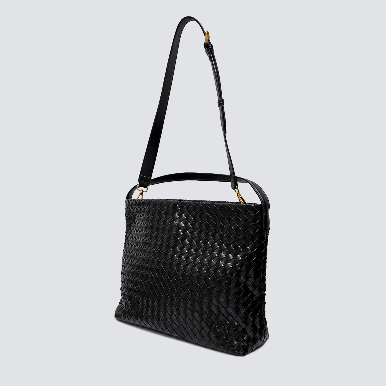 Side angle of the black woven vegan leather shoulder bag with crossbody strap