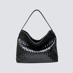 Front view of a black woven vegan leather slouchy tote bag with a top handle
