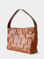 Angled profile of the brown genuine leather woven handbag, perfectly balancing a slouchy aesthetic with a structured base.