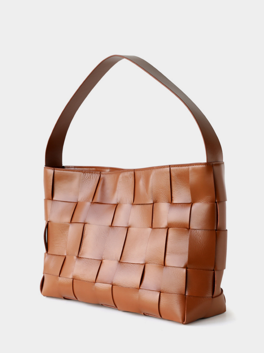 Angled profile of the brown genuine leather woven handbag, perfectly balancing a slouchy aesthetic with a structured base.