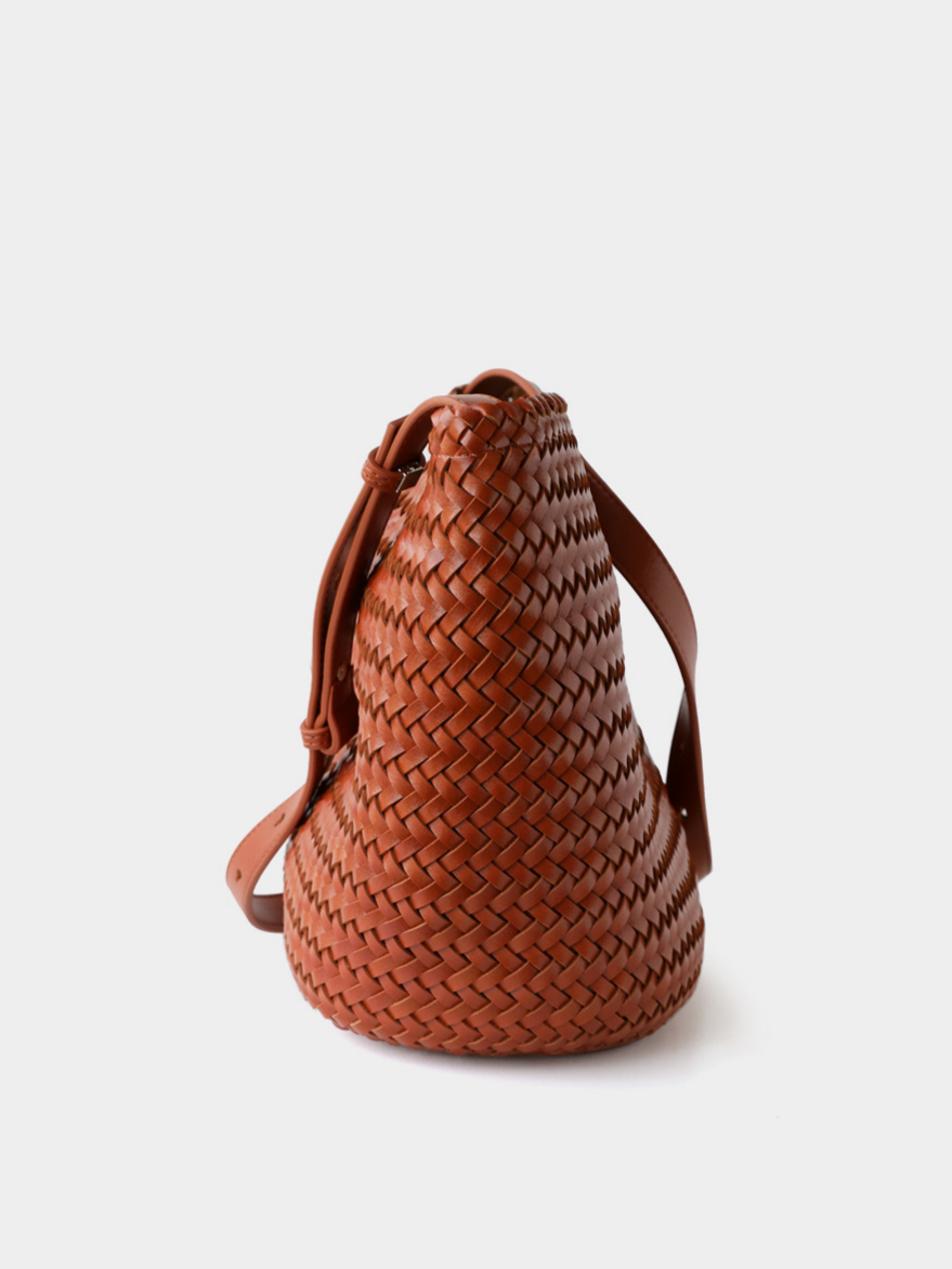 Side profile of the brown woven vegan leather tote bag, demonstrating its spacious teardrop silhouette.