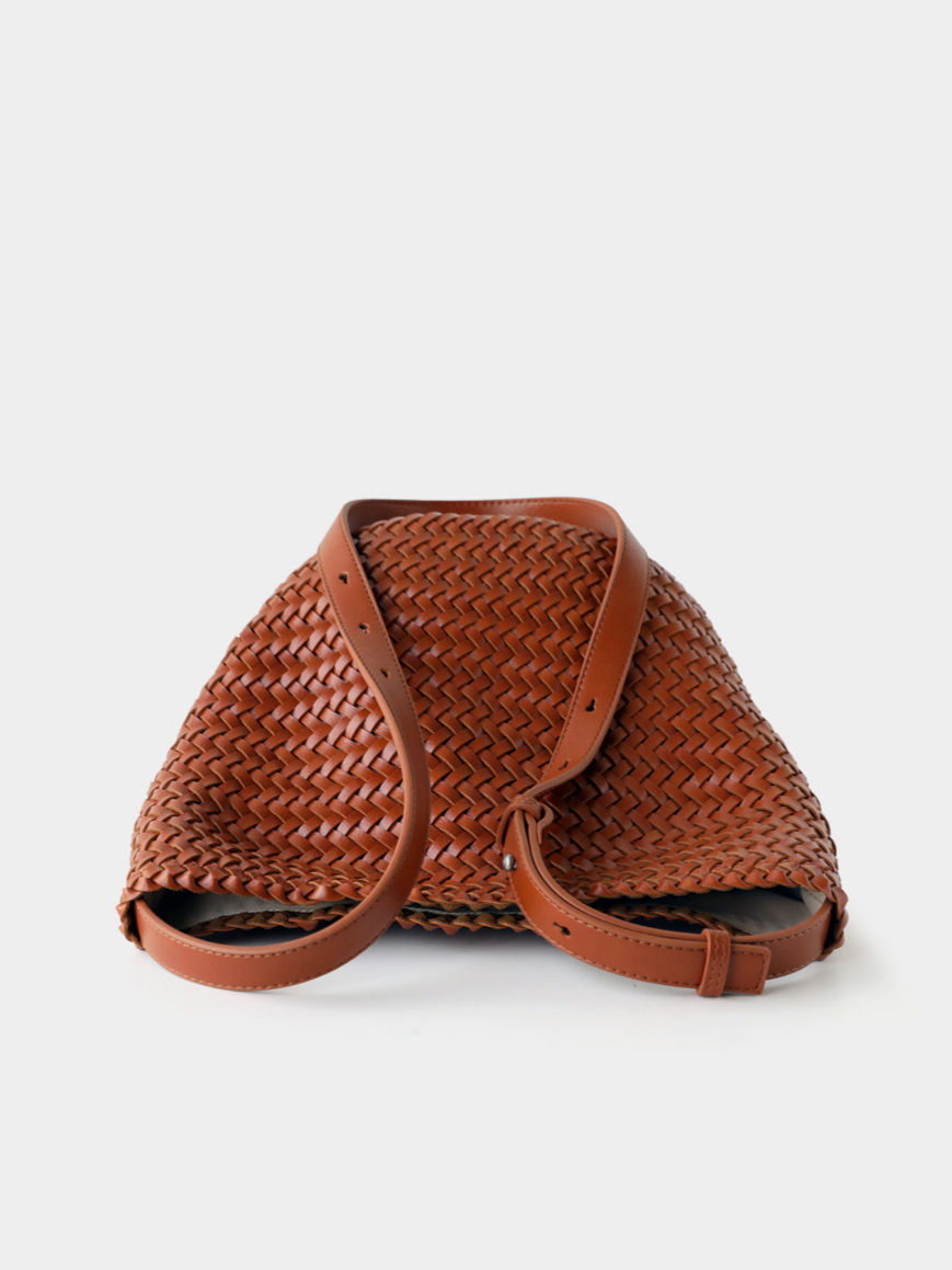 Top-down view of the brown handwoven vegan leather bucket tote, showing its soft yet structured silhouette and premium adjustable strap.
