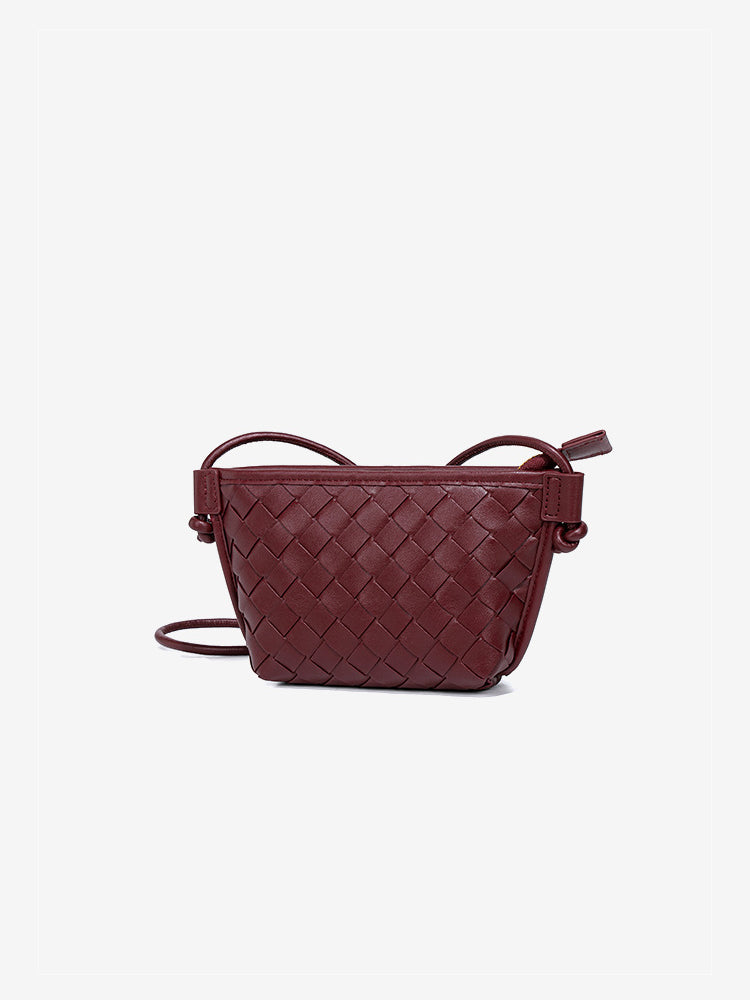 Front view of the elegant burgundy red woven vegan leather bag with a minimalist woven texture and knotted accents.