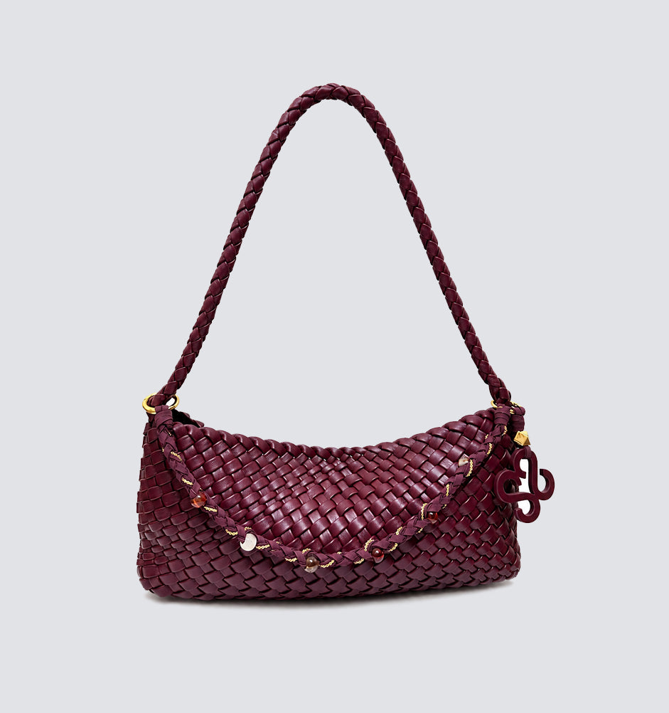 Front view of a burgundy woven vegan leather baguette shoulder bag with braided strap