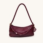 Front view of a burgundy woven vegan leather baguette shoulder bag with braided strap