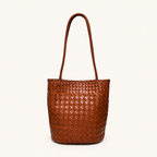 Front view of a cognac brown woven vegan leather bucket bag with slim shoulder straps