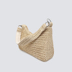 Angled view of the woven straw summer bag featuring a short canvas shoulder strap