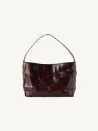 Front view of the elegant dark burgundy wide-weave genuine leather shoulder tote bag with a sleek minimalist finish.