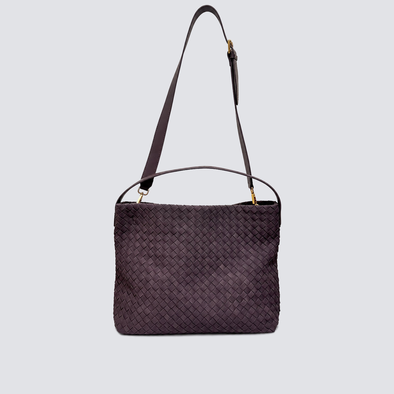 Dark plum woven tote bag displayed with its long adjustable crossbody strap