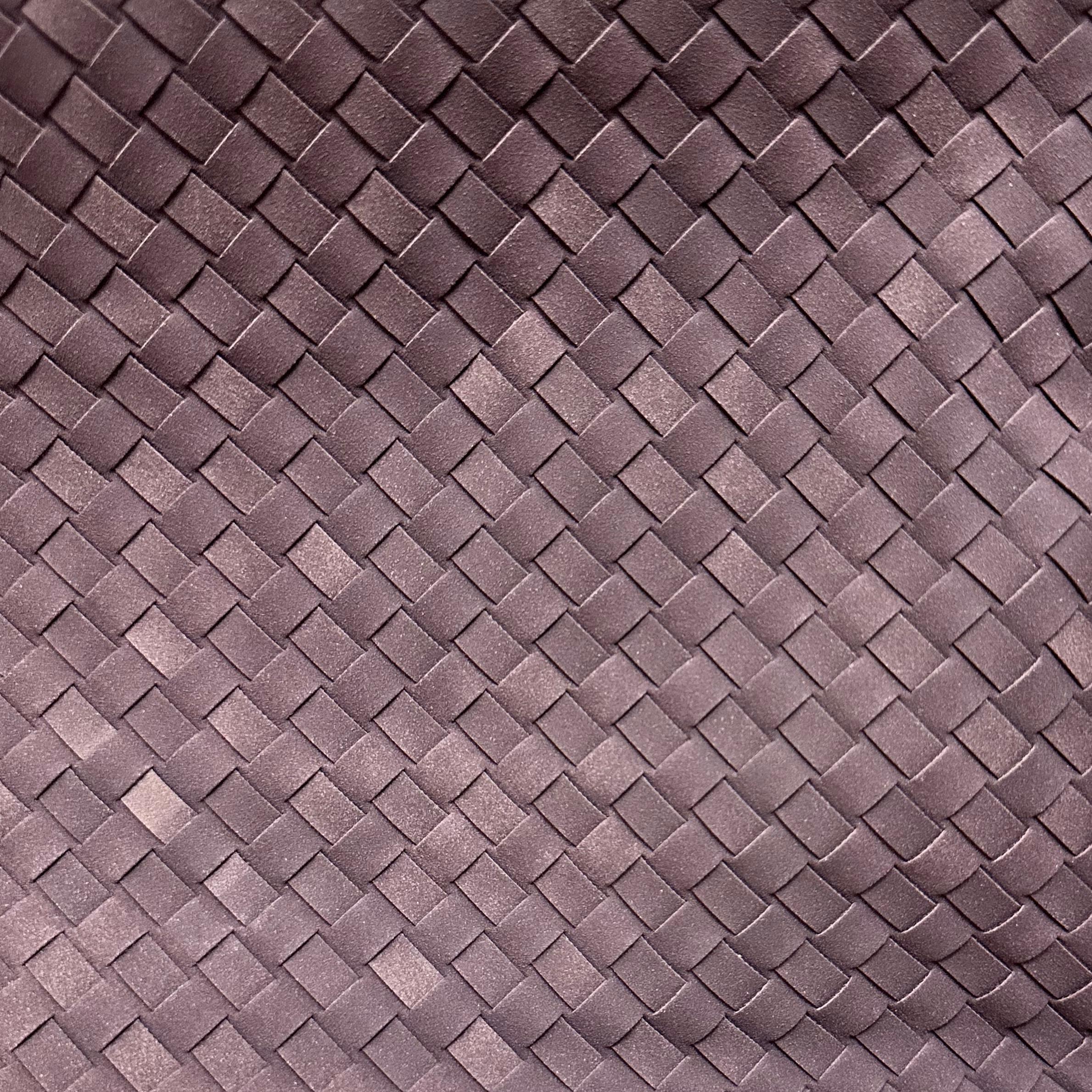 Close-up of the dark plum woven vegan leather texture