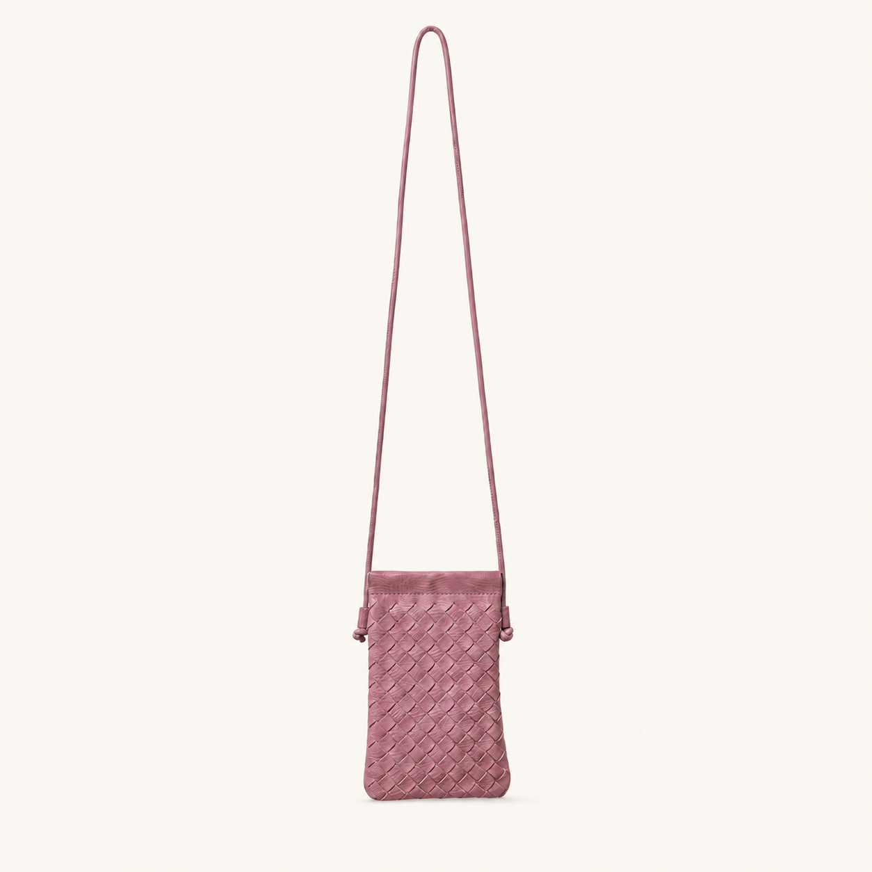 Front view of a dusty rose pink woven vegan leather crossbody phone bag with a long strap