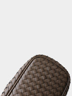 Bottom corner craftsmanship detail of genuine leather woven handbag