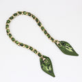 Green botanical leaf print silk ribbon woven into a gold metal bag strap