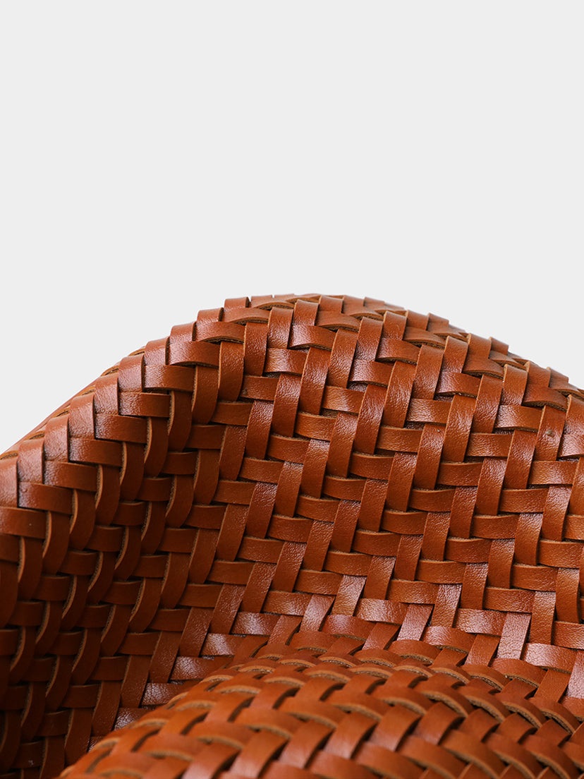 Macro close-up of the meticulous artisan handwoven vegan leather texture on the top edge of the brown bucket tote bag.