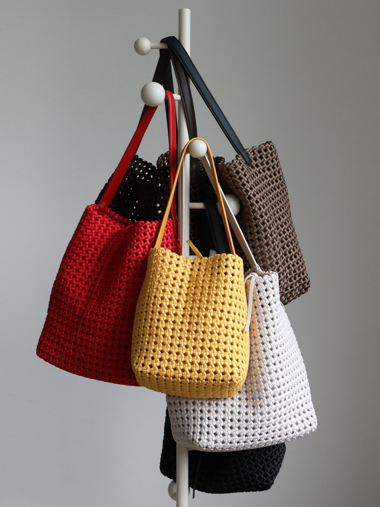 Colorful display rack showcasing the versatile genuine leather woven tote bag in six elegant shades.