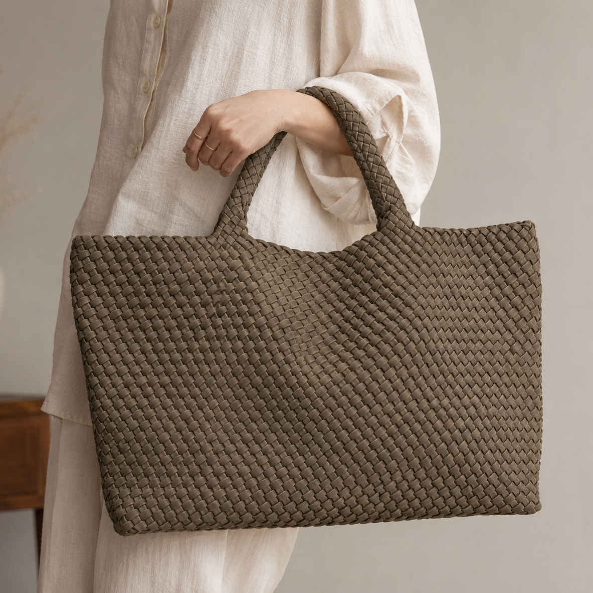 Model in a neutral linen outfit carrying the large taupe woven vegan leather tote