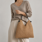 Elegant model in a neutral sweater holding the slouchy woven paper straw summer tote