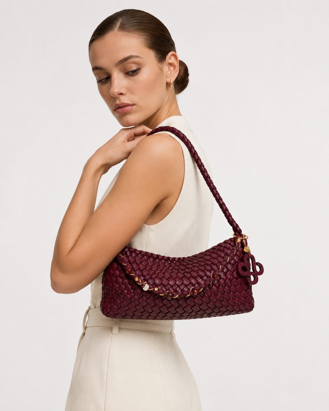 Elegant model styling the burgundy woven baguette bag as a classic underarm shoulder bag