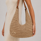 Elegant model in a linen dress wearing the slouchy woven straw hobo bag on her shoulder
