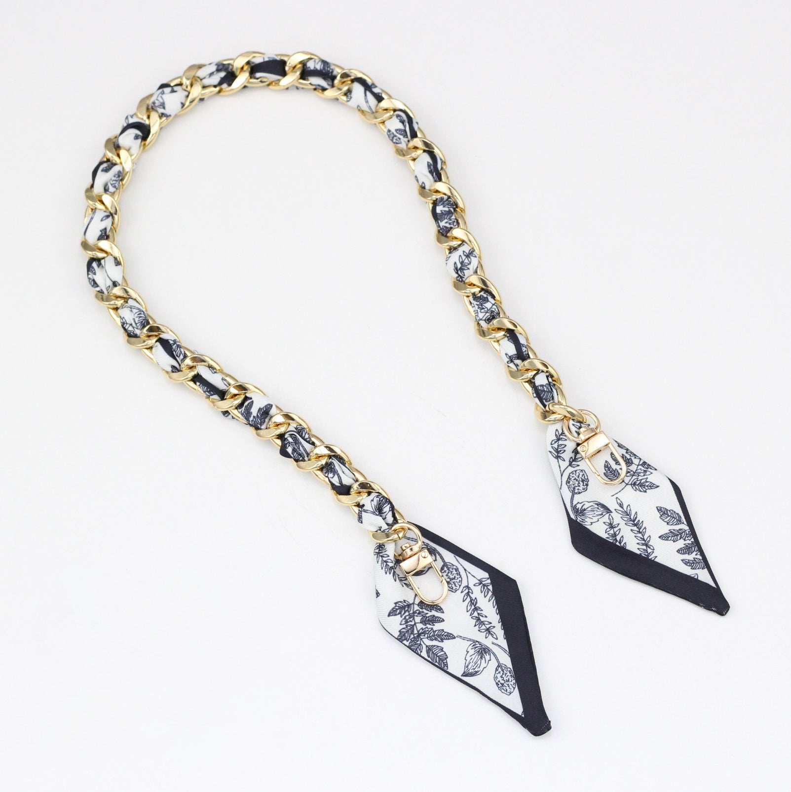 Black and white floral print silk interwoven with a gold bag strap