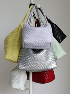 Multi-color collection of woven vegan leather tote bags on display