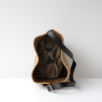 Top-down interior view of the natural raffia hobo bag showing the secure drawstring fabric lining