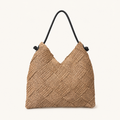 Front view of a natural woven paper straw beach tote bag with a black shoulder strap