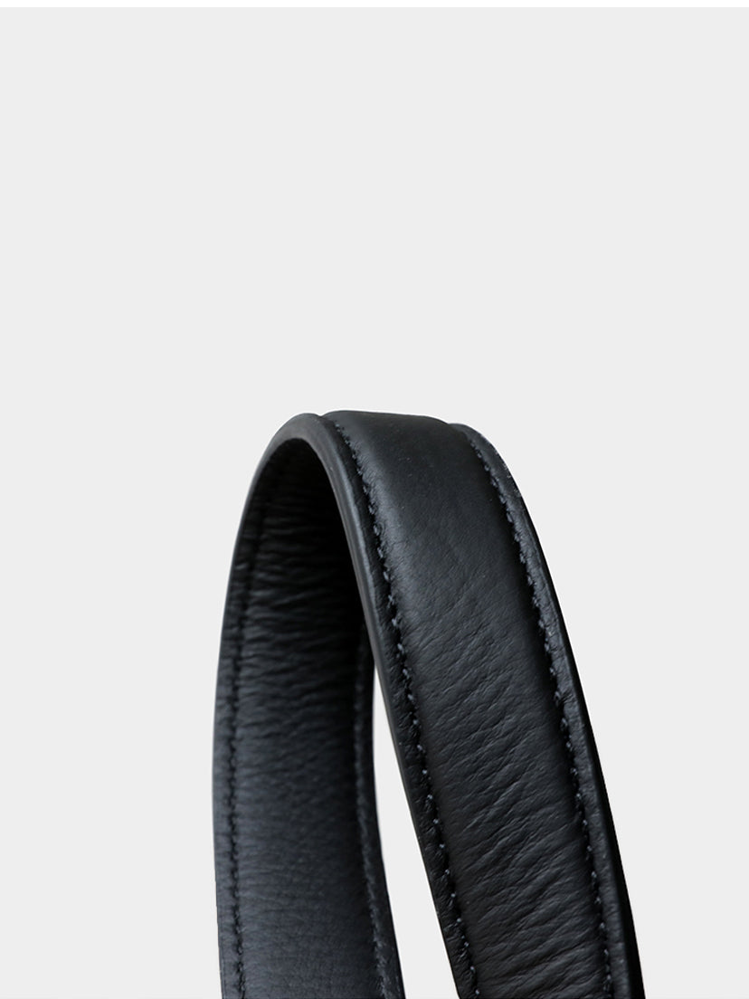 Close-up of the sturdy, comfortable rolled genuine leather shoulder strap on the black woven handbag.