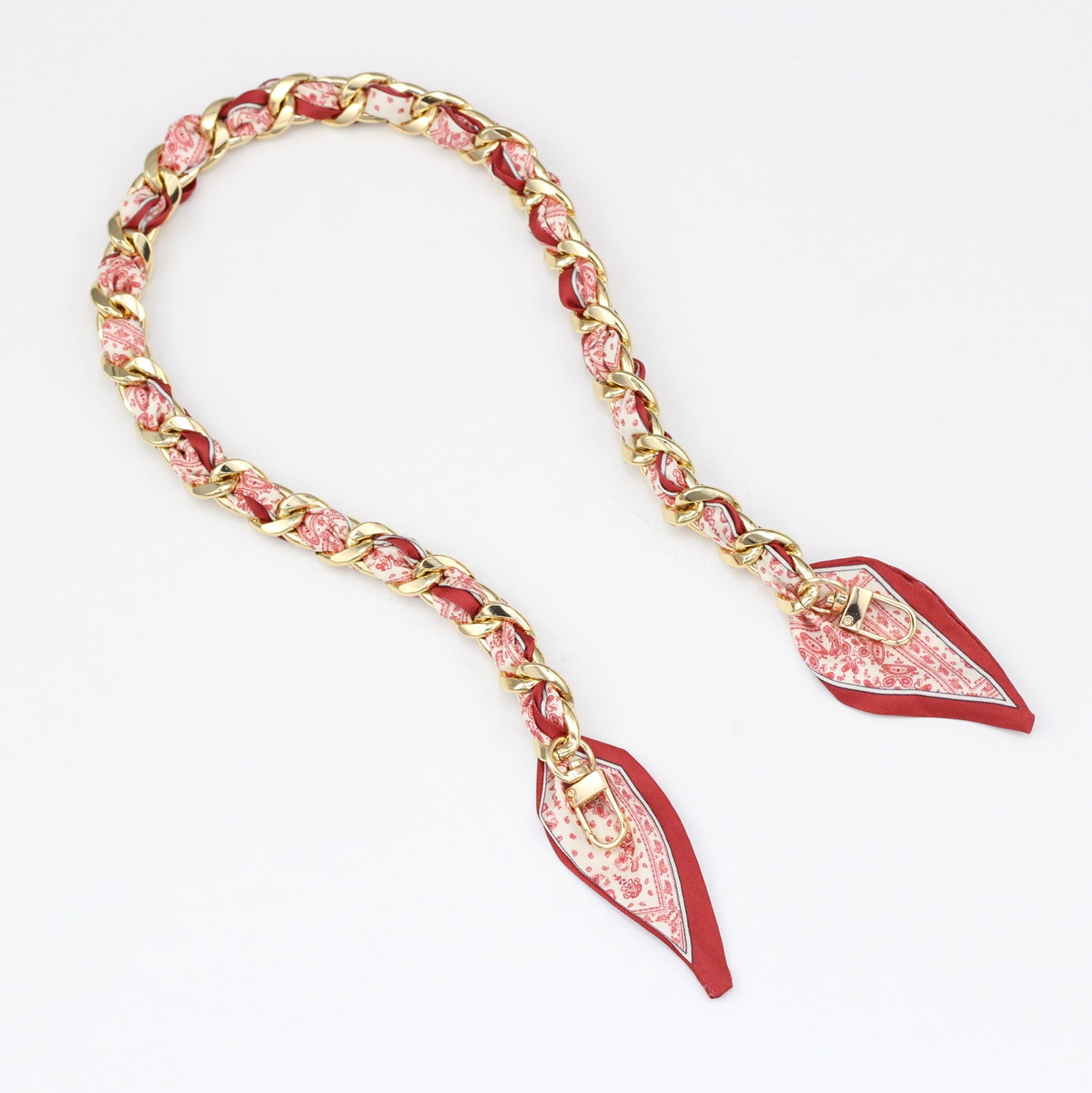 Red print silk scarf braided into a gold handbag chain