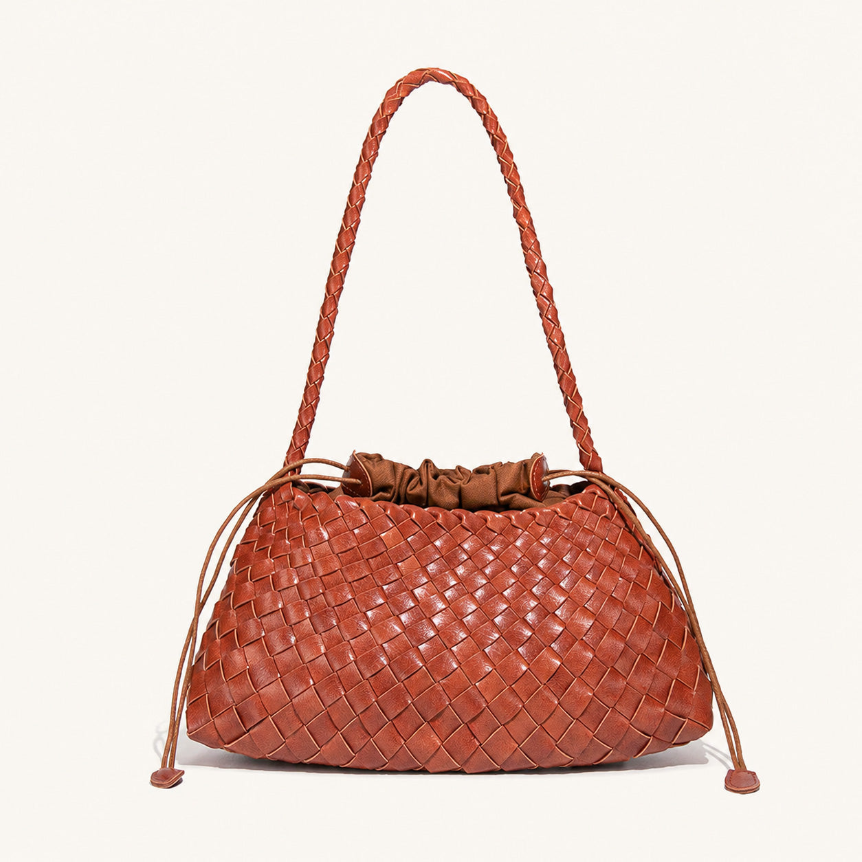 Rust orange woven vegan leather shoulder bag with long handle and curved shape