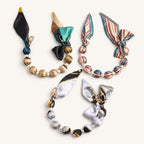 Three silk scarf beaded bag charms in gold, striped, and grey prints