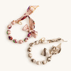 Two silk scarf beaded bag charms in pink floral and ivory chain prints