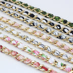 Close-up detail showing silk ribbons braided through chunky gold bag chains
