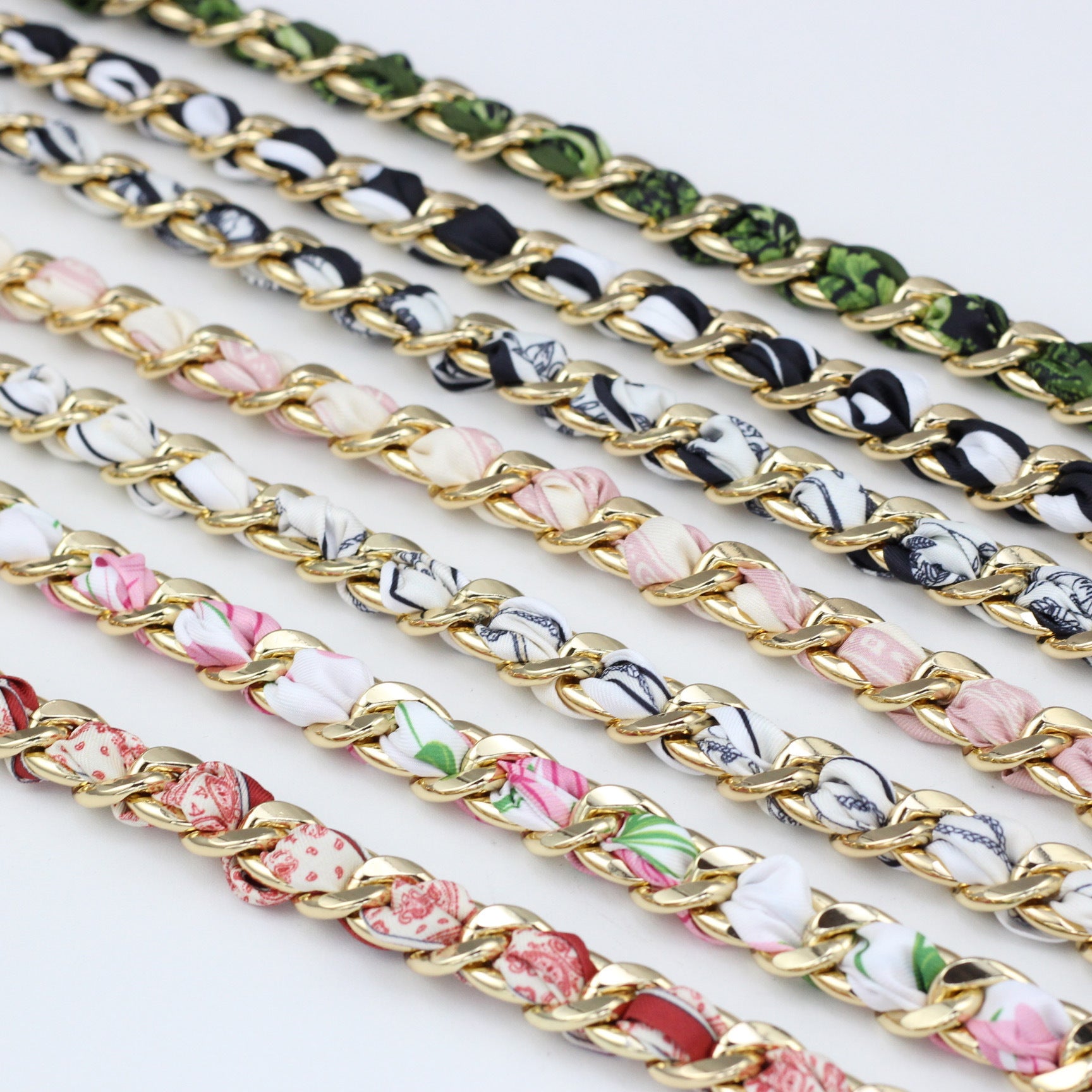 Close-up detail showing silk ribbons braided through chunky gold bag chains
