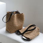 Two natural raffia hobo bags displayed together showing the genuine leather straps