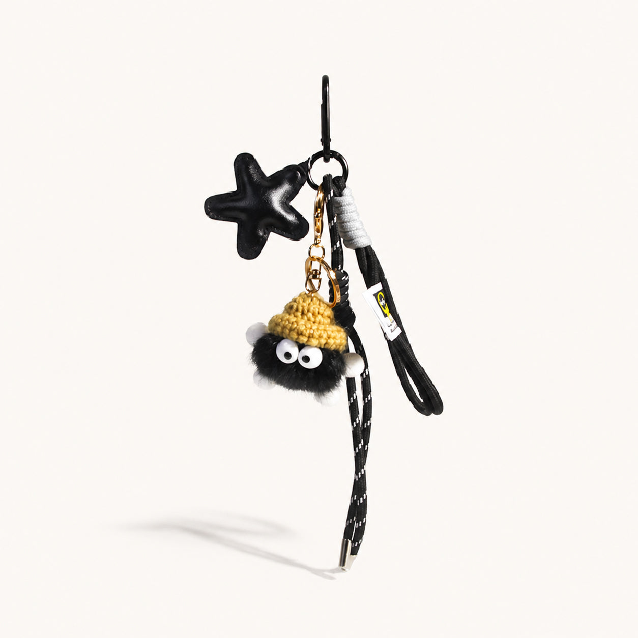Jet black vegan leather star bag charm with black plush pom keychain and all-black cord tassels
