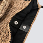 Interior view showing the magnetic snap closure on the woven straw bag