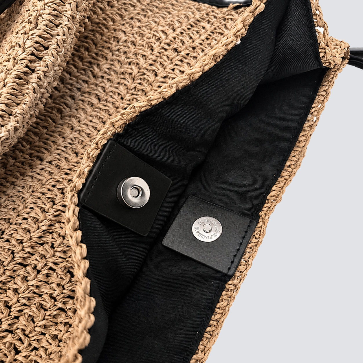 Interior view showing the magnetic snap closure on the woven straw bag