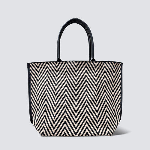 Black and brown chevron knit tote bag with black handles on a simple product background