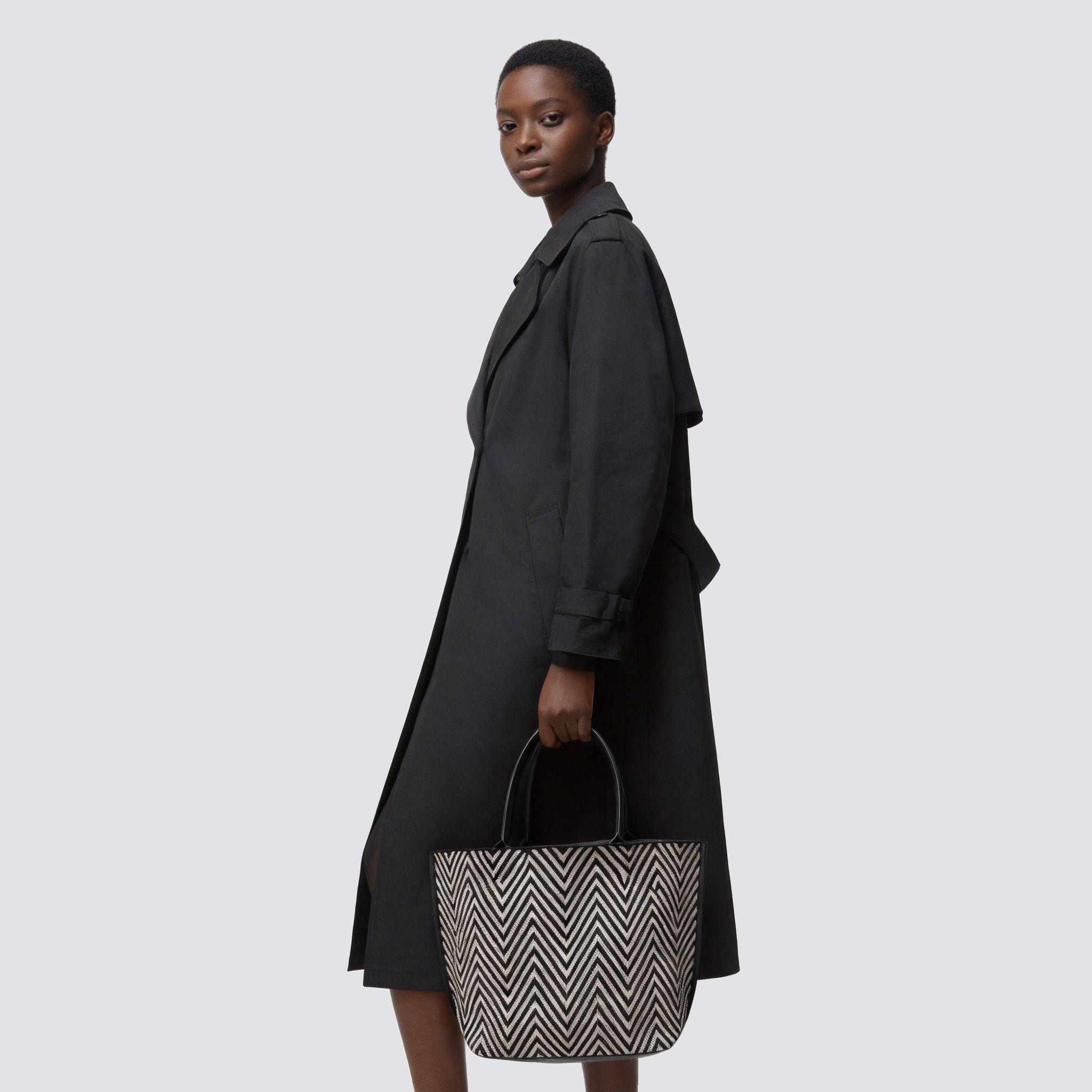 Black and brown chevron knit tote bag carried by hand with an everyday outfit