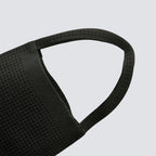 Curved top handle detail on a minimalist black knit mini bag