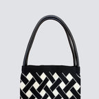 Handle detail of a black and white checkerboard knit tote bag
