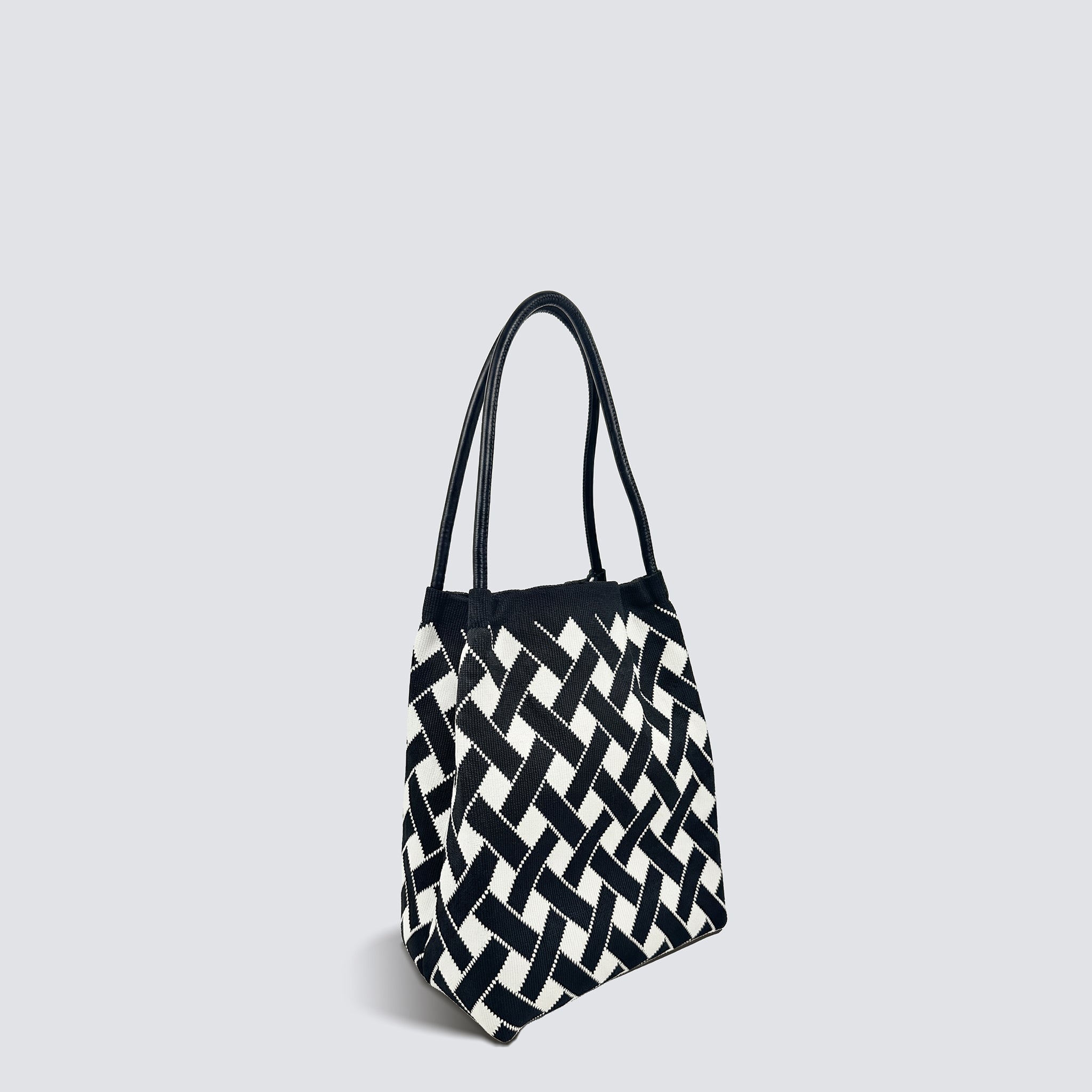 Black and white checkerboard knit tote bag shown with slender handles