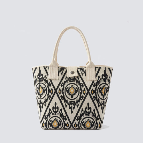 Black and white patterned knit tote bag with long handles on a simple product background