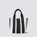 Black and white striped knit tote bag with short handles on a simple product background