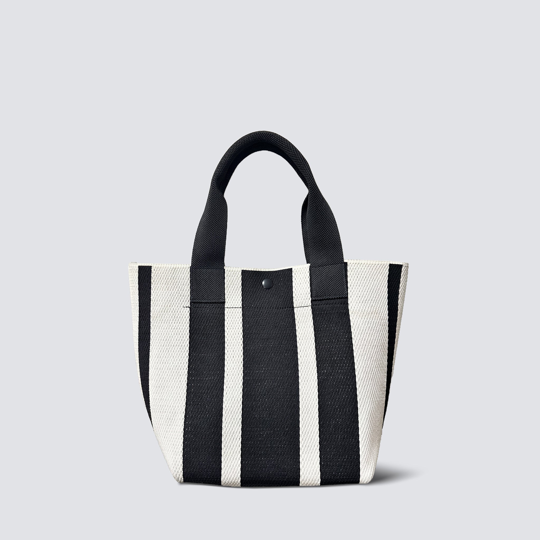 Black and white striped knit tote bag with short handles on a simple product background