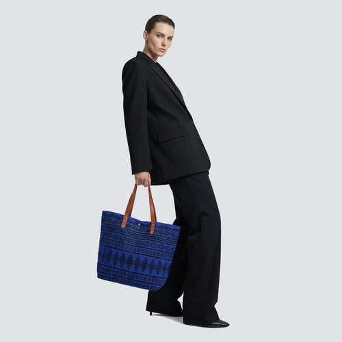 Woman carrying a blue bohemian patterned knit tote bag with a casual outfit
