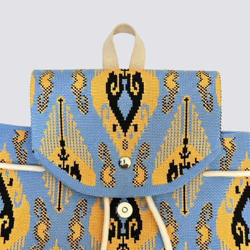 Front detail of a blue and gold bohemian knit backpack with drawstring closure