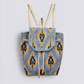 Blue and gold bohemian knit backpack with drawstring and flap closure on a simple product background